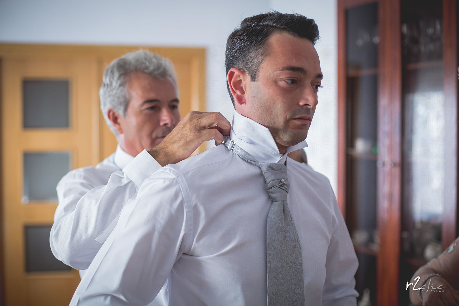 Padre poniendo corbata al novio