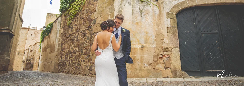 Foto 1244 de r2clic.com - Proyecto 365VecesTeQuiero (Fotos de boda y frases de amor) · Reportaje de boda en Cáceres. Novios abrazados junto a la Torre de Sande, mostrando la cola del vestido extendida. Frase acompañando a foto: · “A veces el paraíso es apoyar la cabeza en el hombro correcto" (Reportaje deboda en Cáceres)