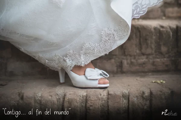 Foto 1254 de r2clic.com - Proyecto 365VecesTeQuiero (Fotos de boda y frases de amor). Reportaje de boda en Cáceres. Zapato y vestido de la novia sobre una escalera. Frase acompañando a foto: · “Contigo… al fin del mundo” (Reportaje de boda en Cáceres)