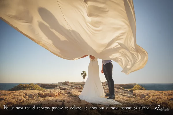 Foto 1273 de r2clic.com - Proyecto 365VecesTeQuiero (Fotos de boda y frases de amor) · Reportaje de boda en Alicante. Novios en la playa cubiertos con el velo flotando en el aire. Frase acompañando a foto: · “No te amo con el corazón porque el corazón se detiene, te amo con el ama porque el alma es eterna” (Reportaje de boda en Alicante)