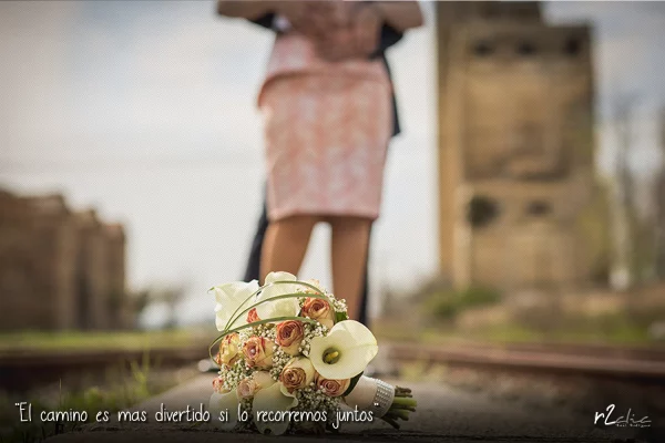 Foto 1276 de r2clic.com - Proyecto 365VecesTeQuiero (Fotos de boda y frases de amor) · Reportaje de boda en Arroyo de la Luz. Ramo de novia entre unas vías de tren. Frase acompañando a foto: “El camino es mas divertido si lo recorremos juntos” (Reportaje de boda en Arroyo de la Luz)