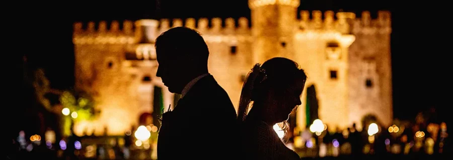 Contraluz de novios de noche con el castillo de fondo. Boda en Cáceres - Reportaje en el Castillo de la Arguijuela [J&Z]